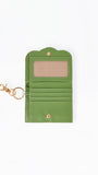 An open green leather wallet with an attached gold-tone keychain clasp, featuring an ID window, card slots, and a snap button closure, shown on a plain white background.