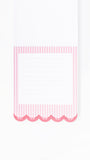 A close-up of a lined notepad page with a pink and white striped border and scalloped bottom edge on a white background.