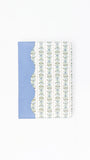 A notebook or journal with a light blue cover on the left and a white cover on the right featuring vertical stripes of small floral motifs, shown on a plain white background.