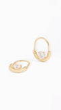 A pair of gold huggie hoop earrings with a clear heart-shaped crystal in the center, displayed on a clean white background.