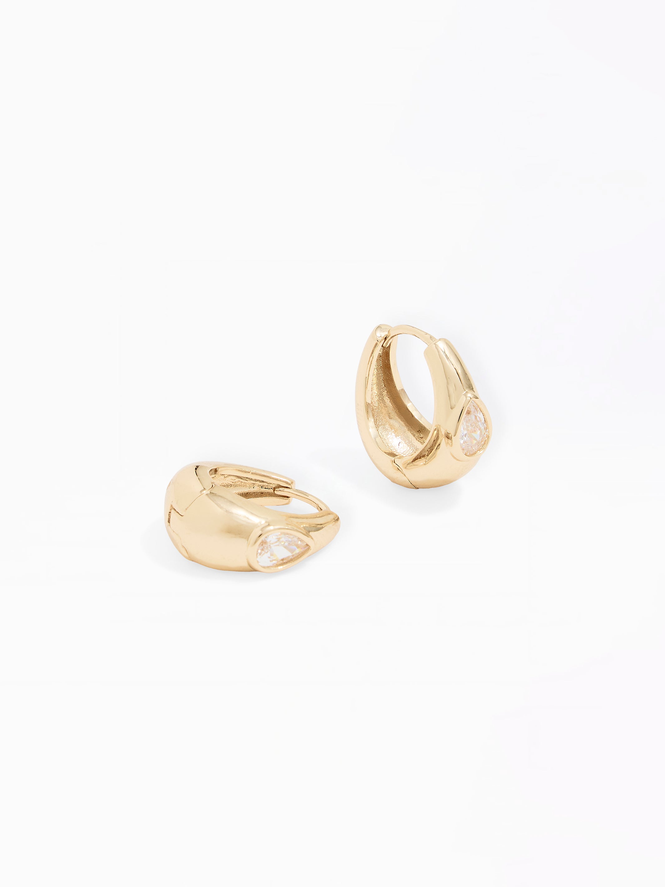A pair of gold huggie hoop earrings with small clear gemstone accents, displayed on a clean white background.