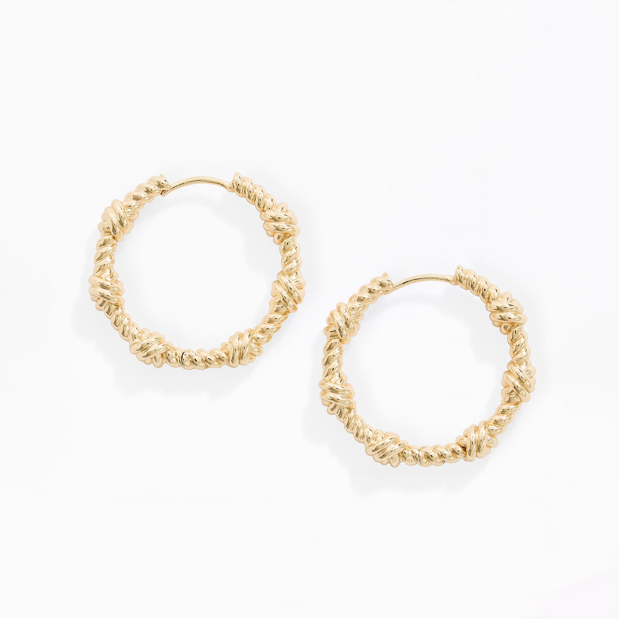 A pair of gold-toned textured hoop earrings with a knotted, rope-like surface detail, displayed on a clean white background.