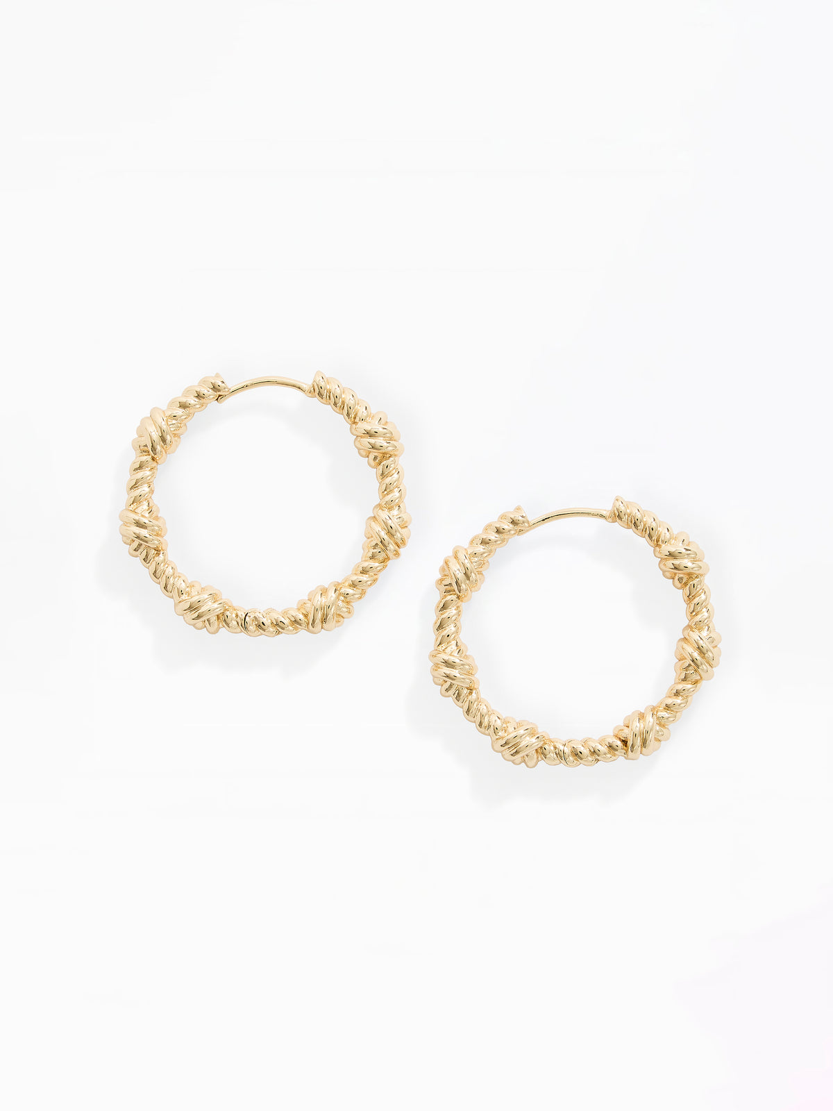 A pair of gold-toned textured hoop earrings with a knotted, rope-like surface detail, displayed on a clean white background.