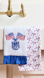Two decorative towels with American flag designs hanging on a kitchen towel rack.