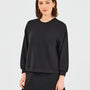 Woman wearing a black sweatshirt and skirt set on a light gray background