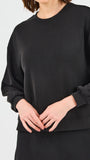 Person wearing a black sweatshirt on a light gray background