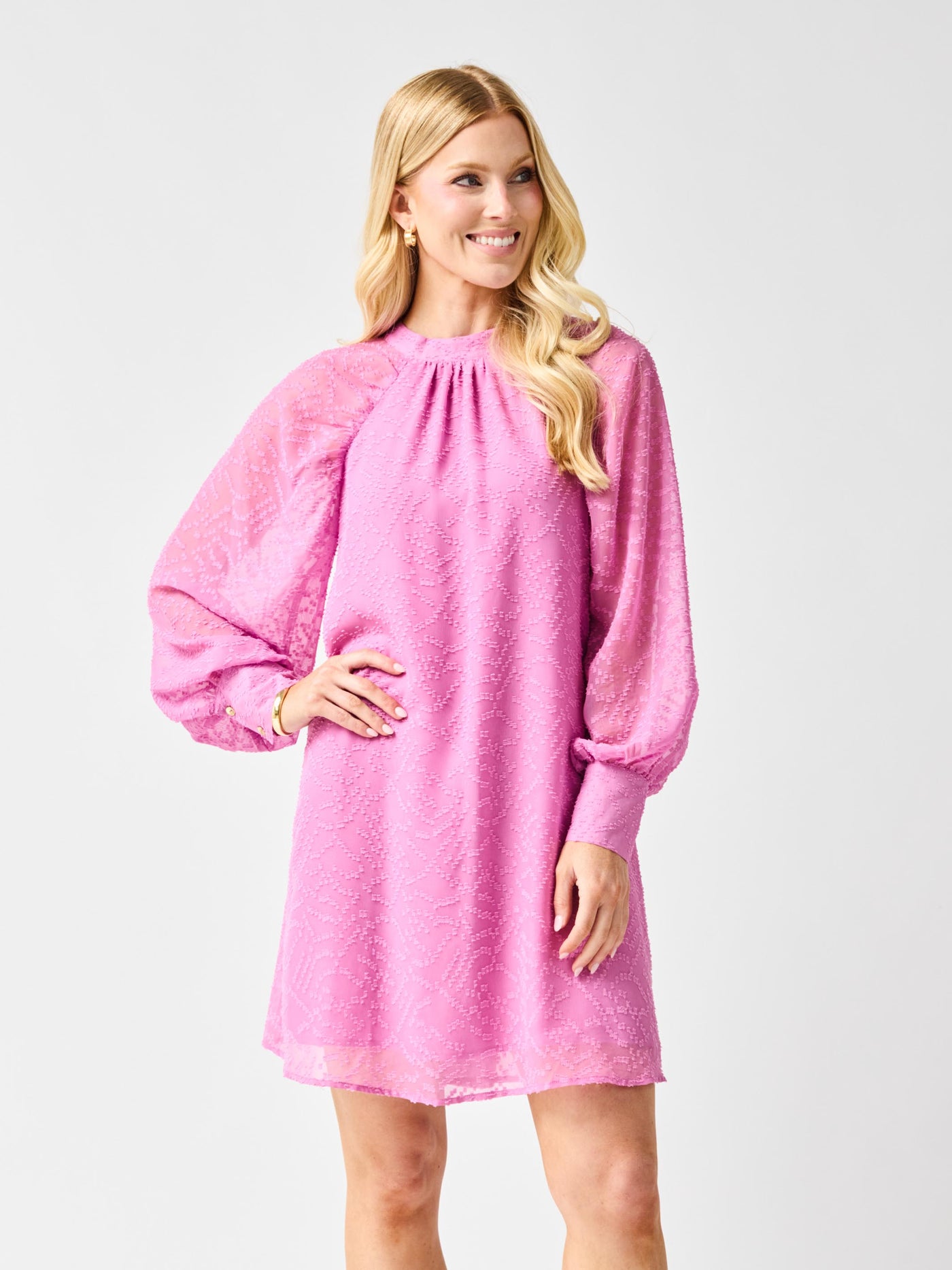 Woman wearing a pink dress with long sleeves on a white background