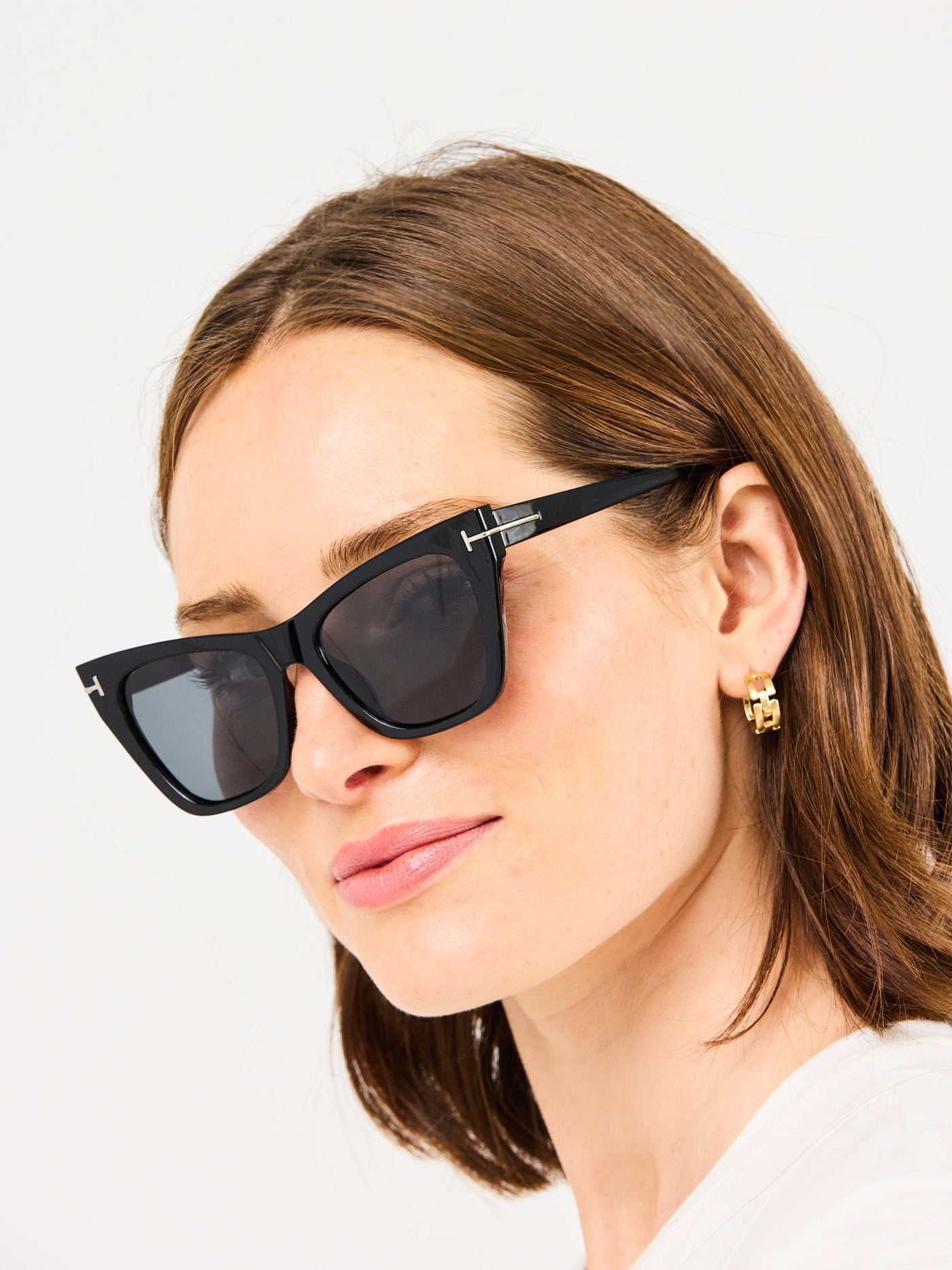 Woman wearing black sunglasses with a neutral background