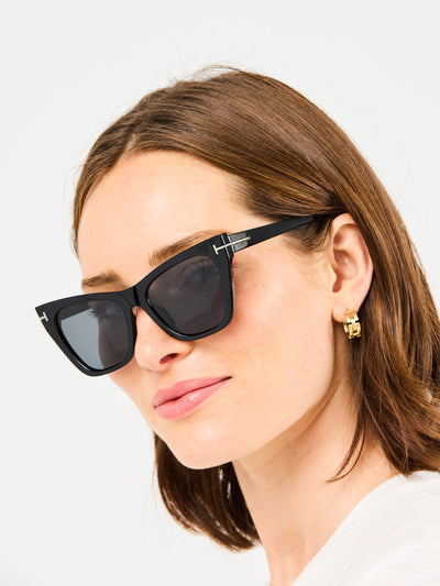 Woman wearing black sunglasses with a neutral background